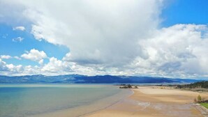 A beach with a clear sky and mountains in the background. - Spacious Condo 3-Minute Walk to Flathead Lake & DT (Bigfork)