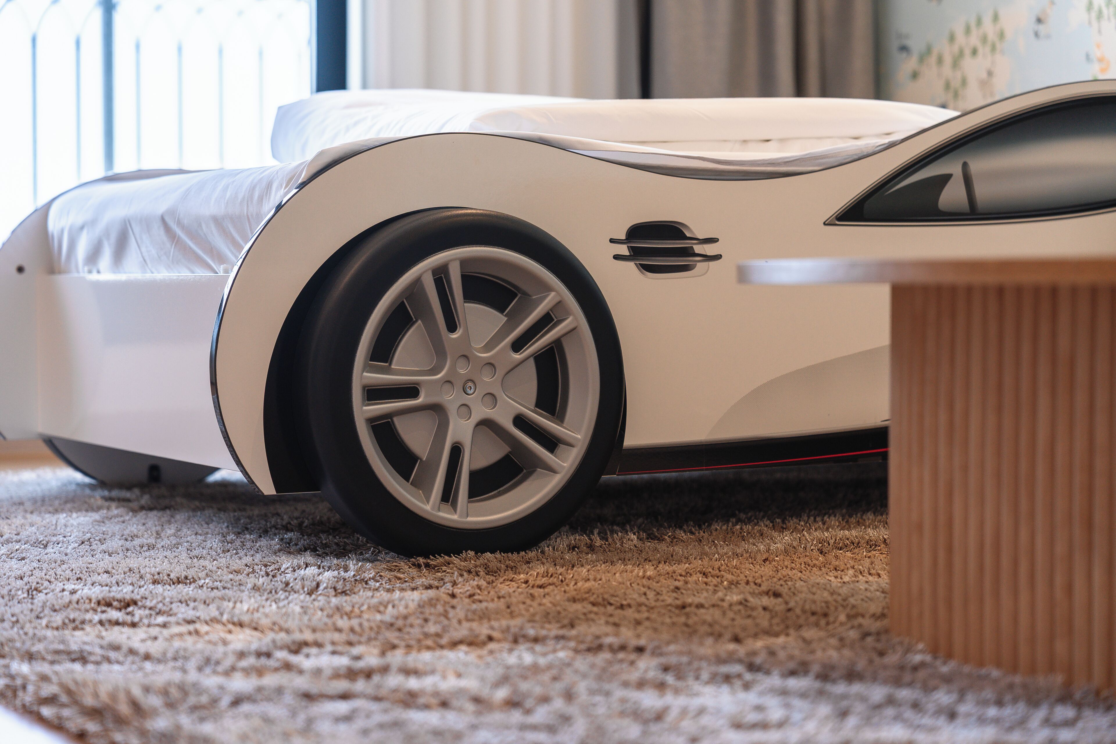 Habitación moderna y minimalista con cama y una mesita.