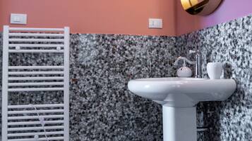 A bathroom with a white sink, a mirror, and a towel rack.