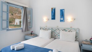 A hotel room with two beds, a window with curtains, wall-mounted artwork, and bedside tables with lamps. - Apartment In A Hotel 'Pico Bello Patmos 22' with Mountain View, Wi-Fi and Air Conditioning (Patmos)