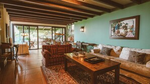 A cozy living room with a wooden ceiling, a large window, and a chessboard on the coffee table. - Country House in Gran Canaria with Private Pool (San Mateo)