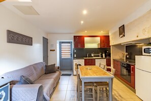 A compact living space with a kitchenette, a dining area, and a sofa.