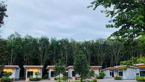 A row of modern, two-story buildings with a gravel courtyard, surrounded by dense forest. - Suanvadee Resort (Koh Samui)