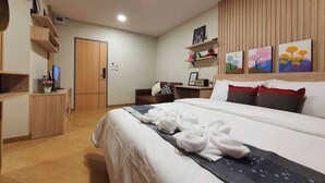 A hotel room with a bed, a desk, a TV, and artwork on the wall. - Increase Hotel&residence (Bang Phli)