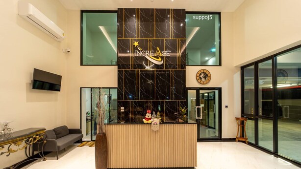 A reception area with a marble counter, a clock, and a large window. - Increase Hotel&residence (Bang Phli)