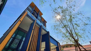 A modern building with a glass facade and a wooden accent. - Increase Hotel&residence (Bang Phli)