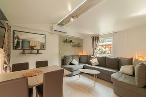 A modern living room with a sofa, a dining table, and a coffee table.