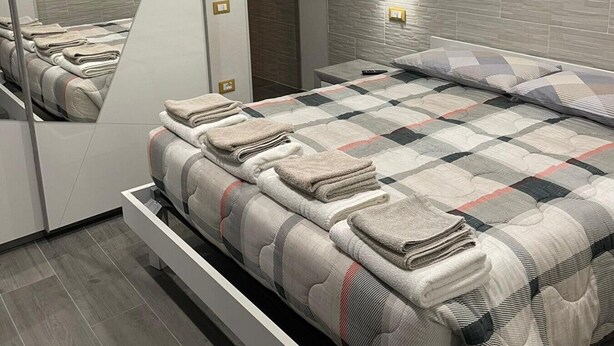 Ein modernes Schlafzimmer mit einem Bett, einem Spiegel und einer Wandleuchte.