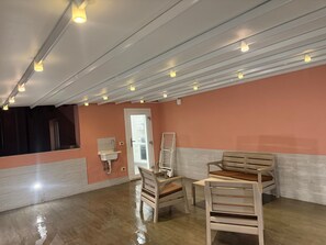 A room with a wooden floor, a white sink, a door, and two wooden chairs. - Apartment "Il Paradiso Holiday" with Private Terrace, Air Conditioning, and Wi-Fi (Ravenna)