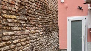 Eine Ziegelwand, eine Tür und ein gefliester Boden.