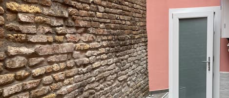 Un mur de briques, une porte et un sol carrelé.