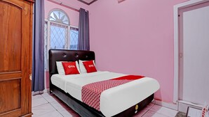 Une chambre à coucher avec un lit, des rideaux, une fenêtre et une armoire.