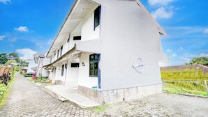 Un bâtiment à deux étages, doté d’un toit en pente, d’un balcon bien visible et d’une enseigne sur laquelle on peut lire le mot « Villa ».