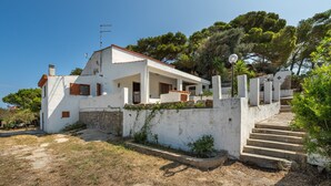 A white building with a stone wall, a staircase, and a clear sky. - Holiday Home 'Cala Lunga' with Private Terrace and Private Garden (Carloforte)