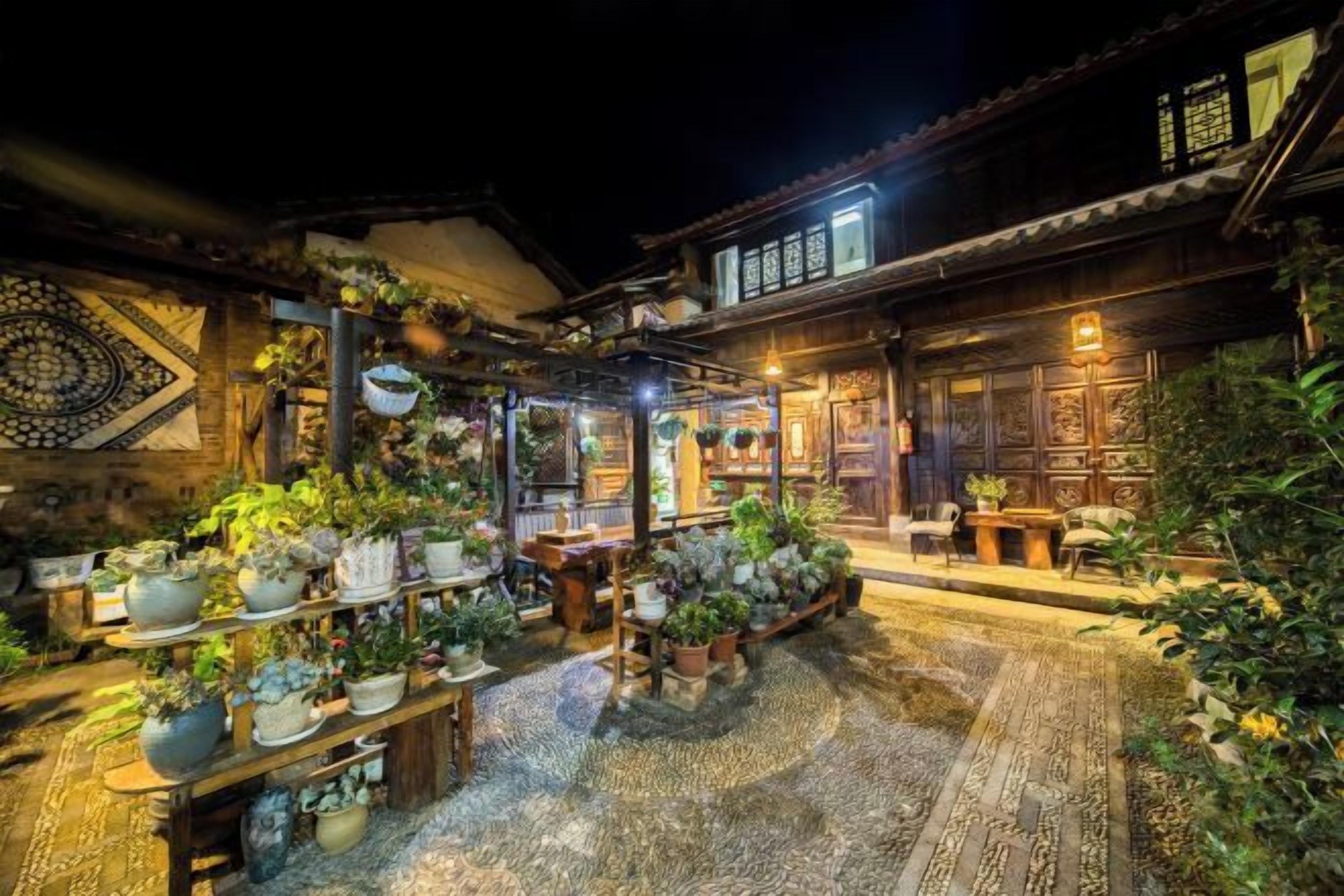 A traditional building with a courtyard filled with potted plants and a wooden table.