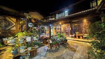 A traditional building with a courtyard filled with potted plants and a wooden table.
