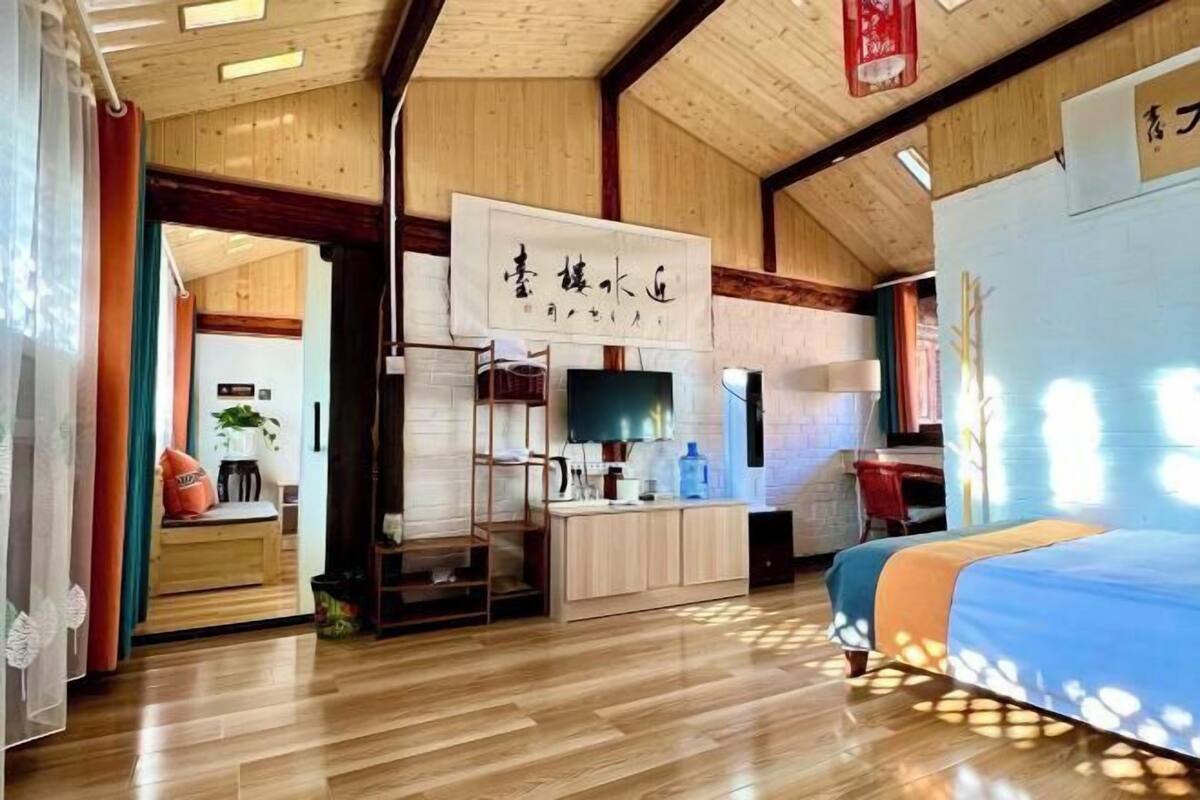 Ein traditionell japanisch gestalteter Raum mit Holzboden, einem Bett mit blauer Bettdecke, einem Fernseher und einem Holzkasten.