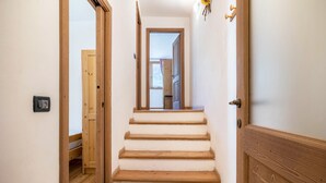 A wooden staircase leading to a room with a bed and a window. - Holiday Apartment "Agritur Piazera Con Terrazzo" with Mountain View (Ronzo Chienis)