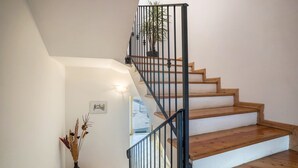 A staircase with wooden steps and black metal railings, leading to an upper floor. - Holiday Apartment "Agritur Piazera Con Terrazzo" with Mountain View (Ronzo Chienis)