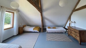 A bedroom with two beds, wooden beams, a dresser, and a window with curtains. - Maison Solognote au Coeur des Châteaux de la Loire (Tour en Sologne)