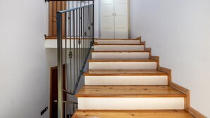 A staircase with wooden steps and metal railings, leading to a door with a white frame.