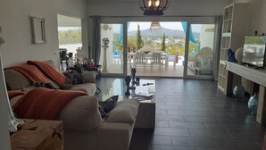 Un salon moderne avec un canapé, une table basse et une vue sur l’extérieur.