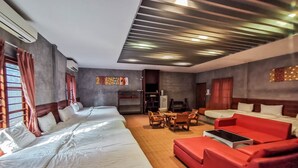 Een hotelkamer met twee bedden, een rode bank, een houten tafel en een televisie.