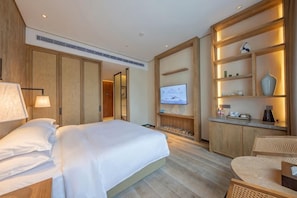 A hotel room with a bed, a television, and a kitchenette. - Azure Reserve Deqing (DEQING)