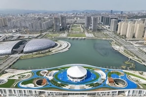 Un hôtel de grande hauteur offrant une vue sur le paysage urbain, avec une fontaine circulaire en premier plan.