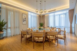 A dining area with a round table, multiple chairs, and a chandelier. - Azure Reserve Deqing (DEQING)