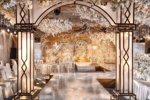 Un espacio interior con una larga mesa, decoraciones florales y un candelabro.