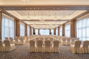 A conference room with rows of chairs, a patterned carpet, and a chandelier. - Azure Reserve Deqing (DEQING)