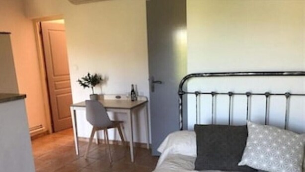 Un dormitorio con cama, escritorio y silla.