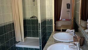 Un baño con dos lavamanos, ducha e inodoro.