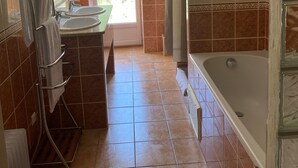 Un baño con bañera, lavamanos y ducha.