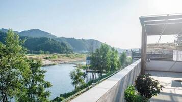 A riverside view with a concrete walkway and greenery.