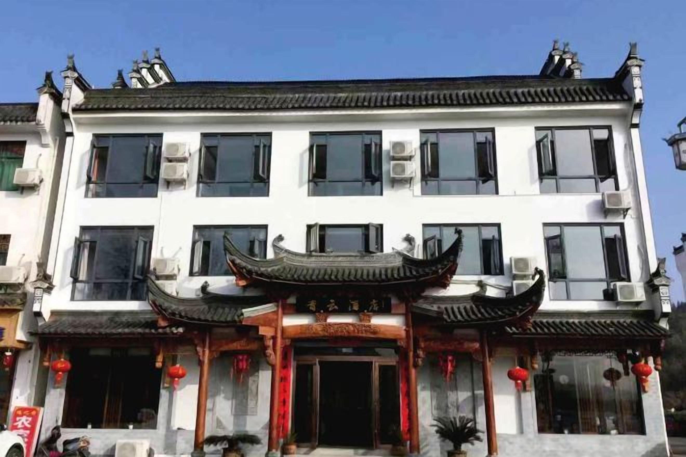 Un edificio tradicional con una entrada destacada, techo de tejas y detalles decorativos.