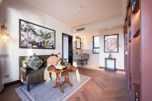 A spacious living area with a sofa, a coffee table, and artwork on the walls. - Amila Guesthouse (Dali City)