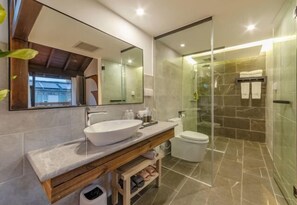 A modern bathroom with a large mirror, a vessel sink, a toilet, and a glass-enclosed shower area. - Amila Guesthouse (Dali City)