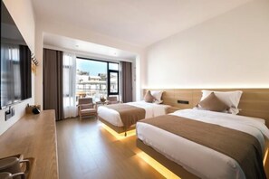 A hotel room with two beds, a desk, and a view of the city. - Dali twilight cang view light luxury inn (Dali)