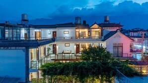 Un immeuble à plusieurs étages, de style architectural traditionnel, doté d’un balcon et d’une entrée bien éclairée.