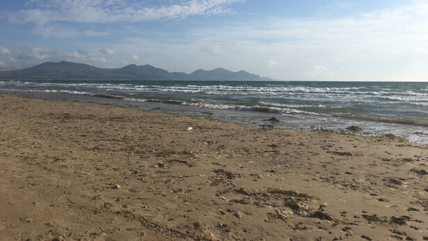 Een strand met een zandstrand en golven.