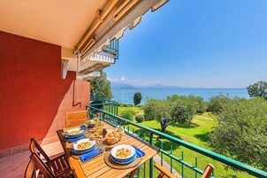 Un tavolo di legno apparecchiato per un pasto con vista su un lago e montagne.