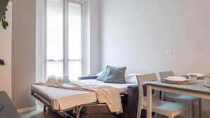 A compact room with a bed, a small table, and a window. - The Best Rent - Apartment in Milan downtown (Milano)