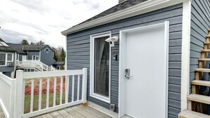 A residential building with a grey exterior, a white door, and a small window with a number '2022' visible. - Chouette Tremblant Ski In/Out Pedestrian Village (Mont Tremblant)