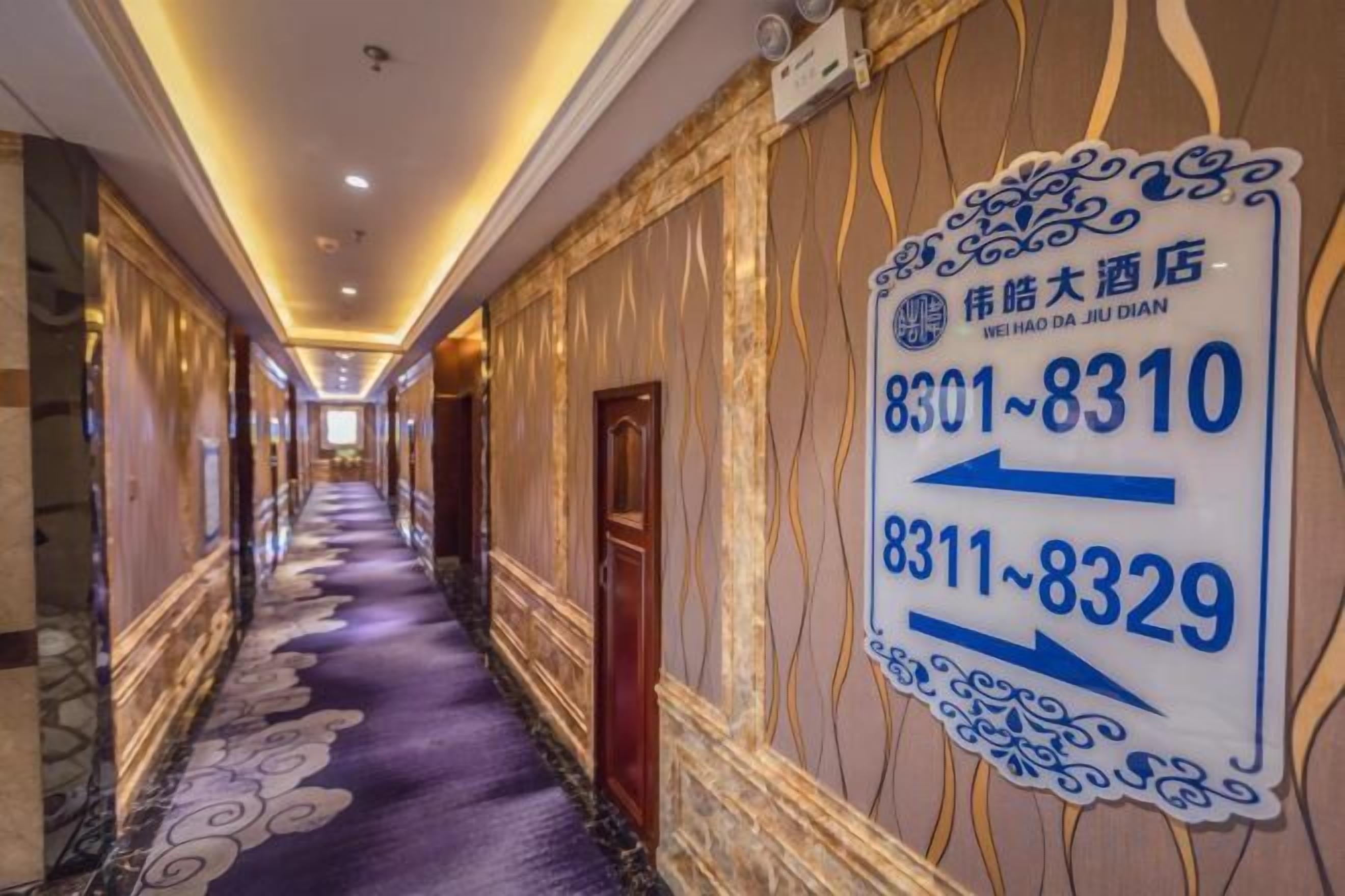 A hotel corridor with directional signs indicating room numbers 8301-8310 and 8311-8329.