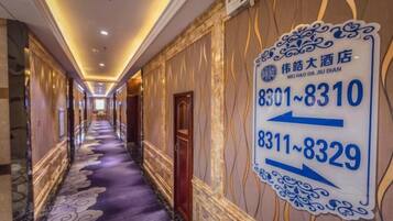 A hotel corridor with directional signs indicating room numbers 8301-8310 and 8311-8329.