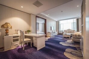 A hotel room with a desk, a chair, a sofa, and a large mirror. - Erenhot Weihao Hotel (Erenhot)