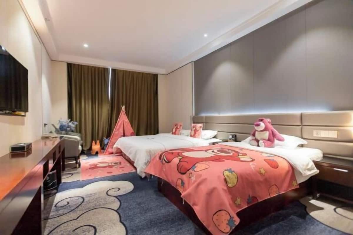 Une chambre d’hôtel avec deux lits, un bureau, une télévision et une grande fenêtre avec des rideaux.
