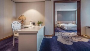 Een hotelkamer met een bureau, stoel en een bed met een blauw gestreept tapijt.